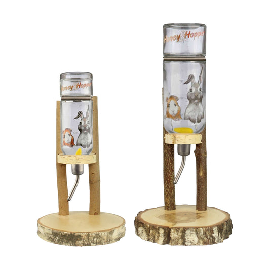 Nagerfarm small animal water dispenser with glass bottle, natural wood base and stand, featuring cute bunny and guinea pig illustrations.